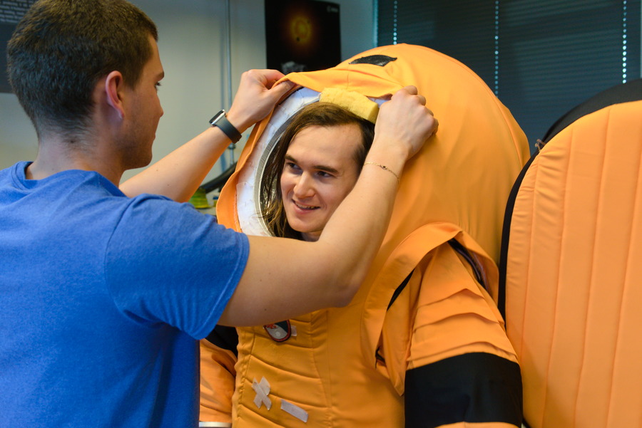 An Asclepios VI astronaut being helped into the suit