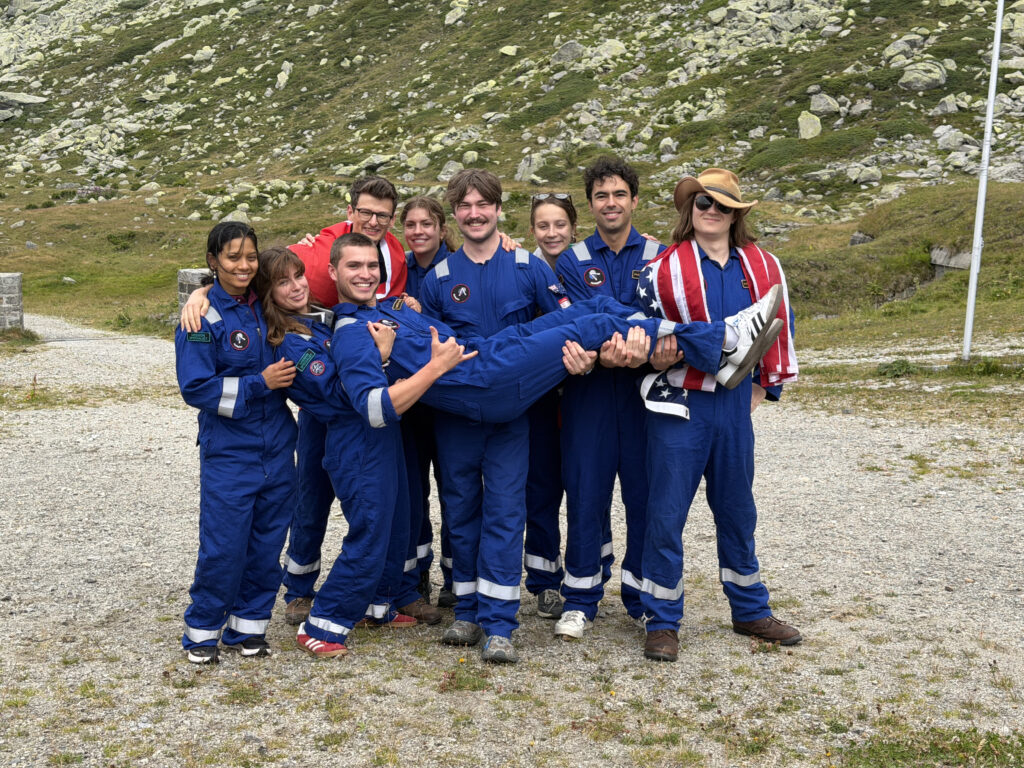 The Asclepios team in blue mission jumpsuits, carrying a crew member across their arms
