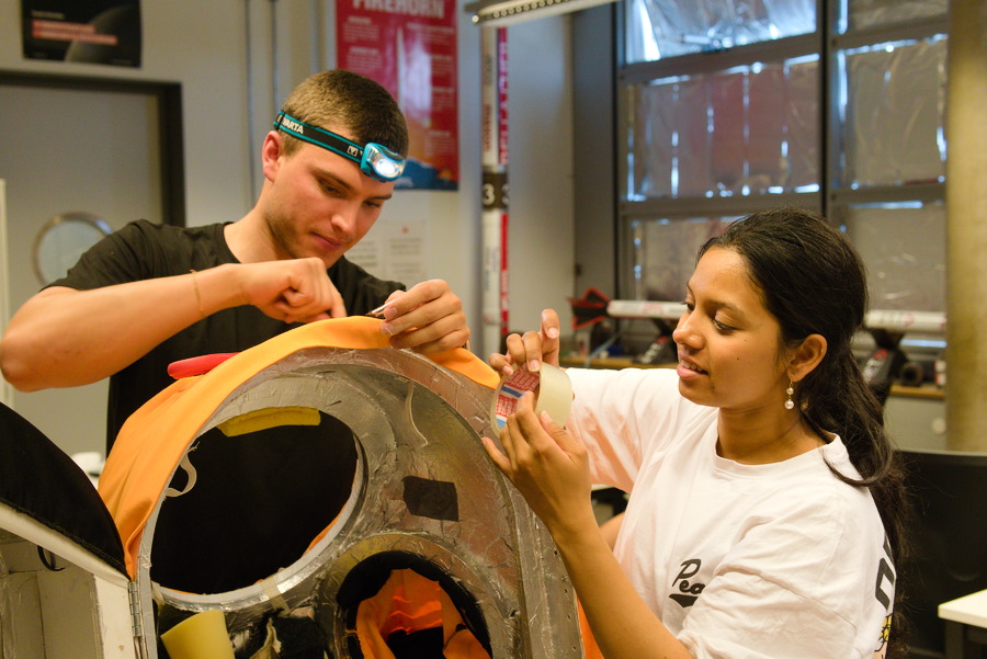 Officers working on flight hardware